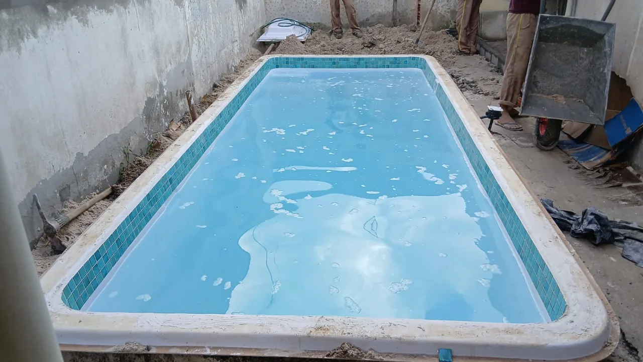 Piscina residencial durante a etapa de instalação com entorno ainda em obra